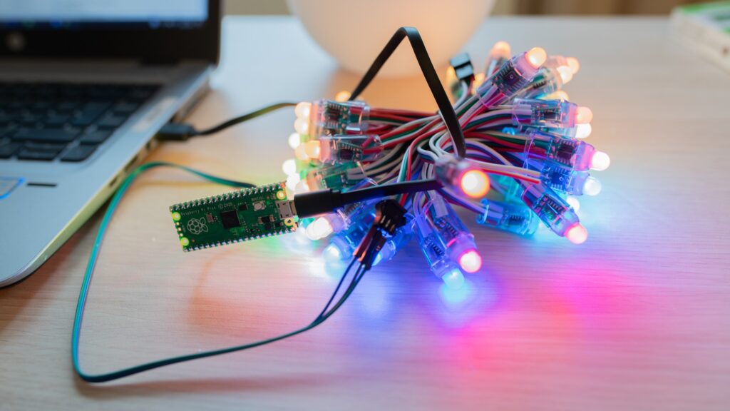 Sladdar med lampor som ligger på ett bord bredvid en laptop.